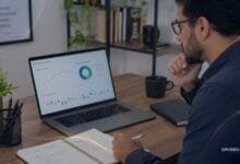 Pessoa analisando gráficos financeiros em notebook para entender a Taxa Selic e seus impactos no crédito e nos investimentos.