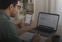 Pessoa analisando oferta de crédito pré-aprovado no celular com caderno de orçamento sobre a mesa.