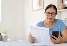 Aposentada consulta extrato e celular após identificar empréstimo consignado não reconhecido