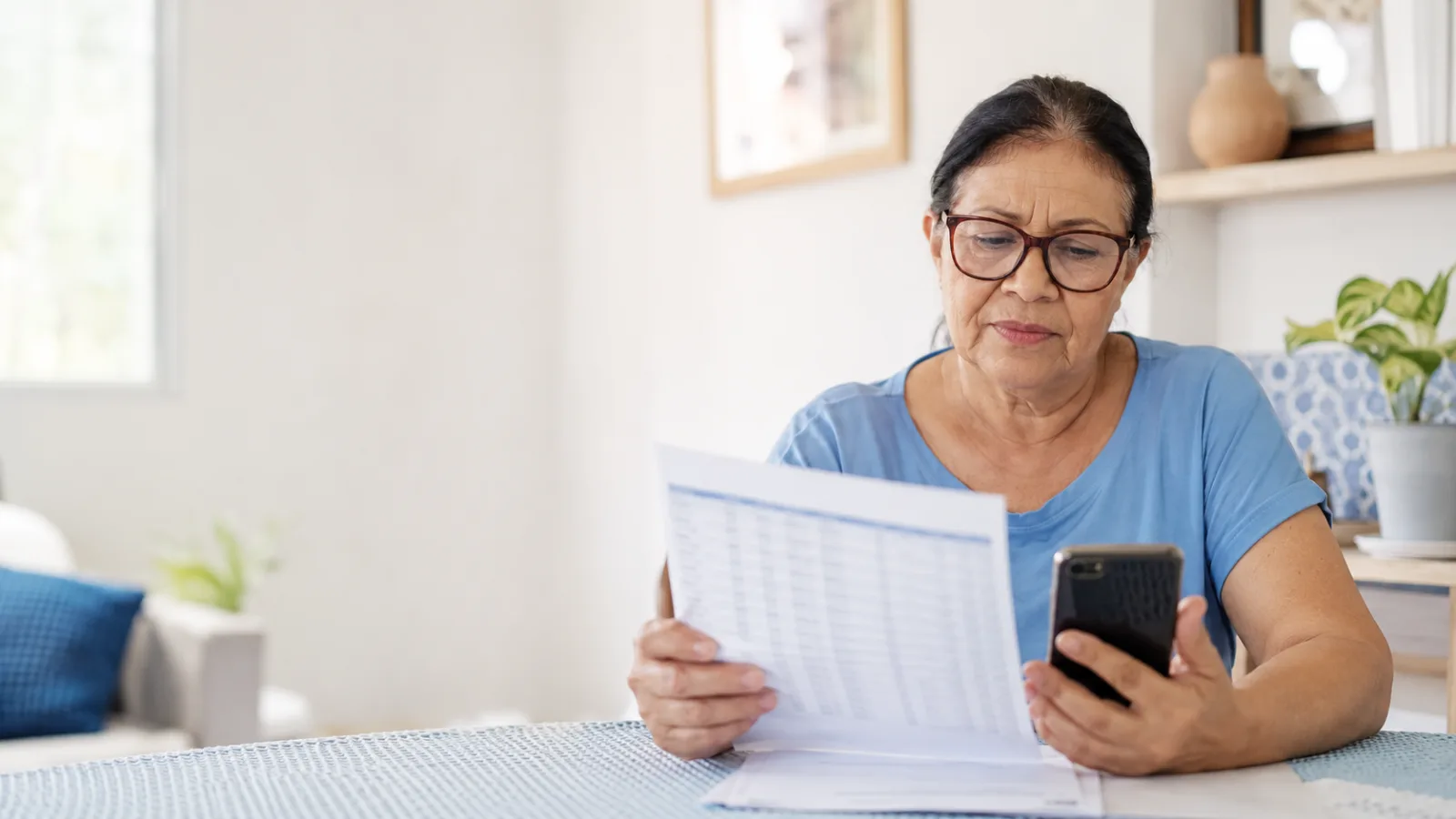 Aposentada consulta extrato e celular após identificar empréstimo consignado não reconhecido